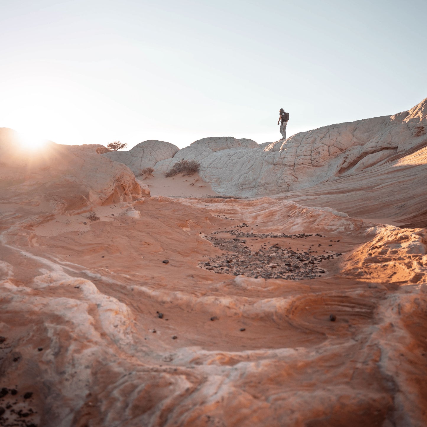 A low shot looking upward, a person walking on the ledge of a rough terrain 