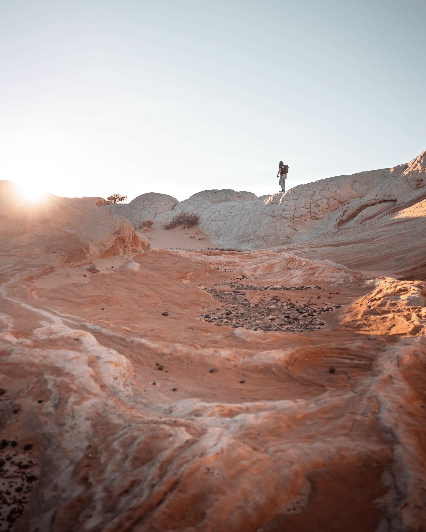 A low shot looking upward, a person walking on the ledge of a rough terrain 